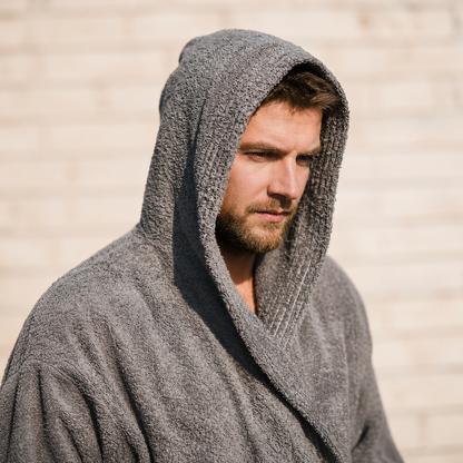 Portret van man met grijze badjas en capuchon in warm daglicht